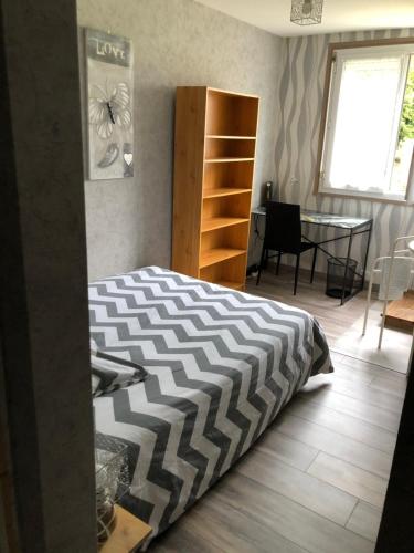 - une chambre avec un lit, une table et une fenêtre dans l'établissement Maison entre Caen et la mer, à Montmorency