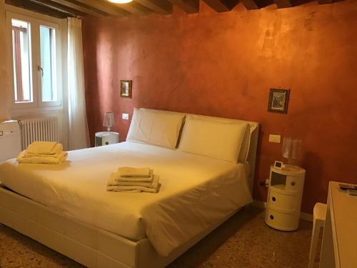 a bedroom with a white bed with towels on it at Fondaco di Rialto in Venice