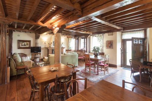 una gran sala de estar con techos de madera, mesas y sillas. en Casa de Campoo, en Naveda