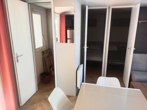 a room with a white table and white chairs at MOBIL HOME LE PRECIEUX in Valras-Plage