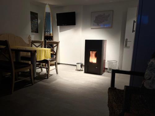 a living room with a fireplace with a table and chairs at Astrid's Pension in Winterberg