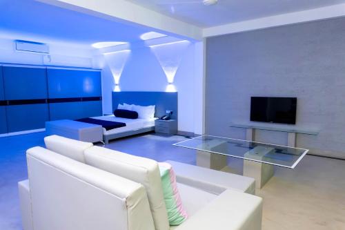 a living room with a white couch and a tv at Josan Villa with a Glorious Beach and Sea View in Habaraduwa