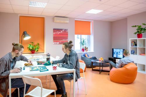 a group of people sitting at a table in a waiting room at Liberty Airy in Rīga