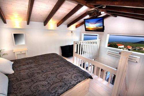 1 dormitorio con 1 cama y TV en la pared en lavelo לה ולו en Safed