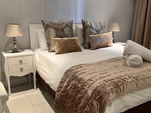 a bedroom with a bed and a nightstand with two lamps at Beacon Rock Apartment 208 in Durban