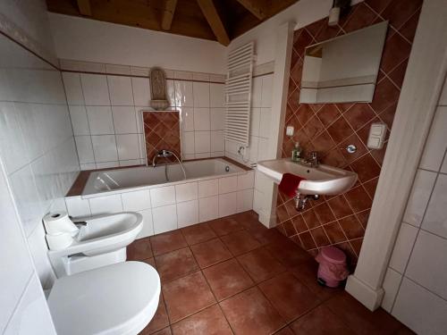 a bathroom with a toilet and a tub and a sink at Villa Toskana Wohnung 2 in Wackersdorf
