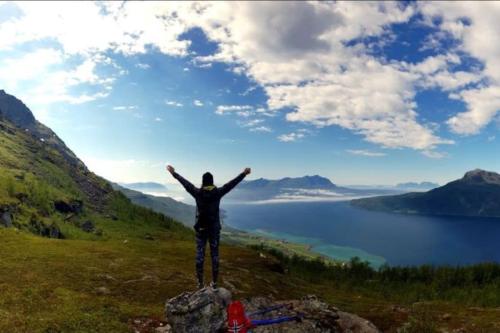 a man standing on top of a rock with his arms outstretched at Norwegian Dream in Gratangen