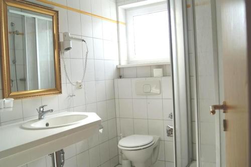 baño con aseo y lavabo y ventana en Ferienwohnung 105 Haus Katharina mit Balkon, en Lauterbach