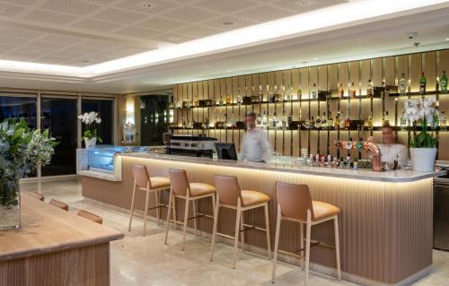 a bar in a restaurant with a man standing behind it at Aria in Eilat