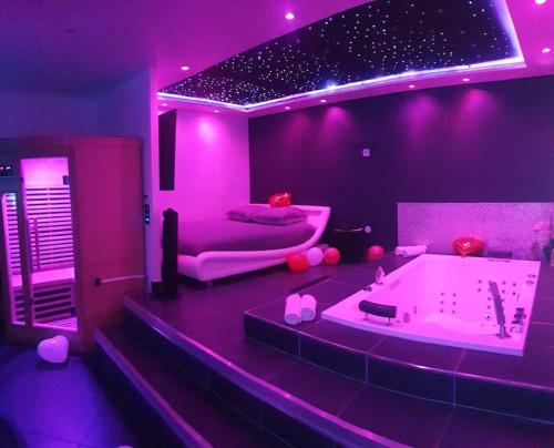 Habitación púrpura con bañera y cama en ESCAPE ZEN Suite & spa privatif, en Chambly