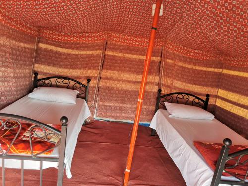 a room with two beds in a tent at Panorama Camp Bidiya in Al Wāşil