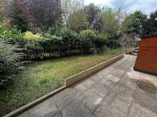 een tuin met een loopbrug en een tuin met bomen bij Appart calme avec jardin et parking. 15mn de Paris in Le Bourget