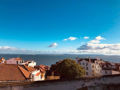 a view of a city with buildings and the water at Santa Clara Lisbon Rooms in Lisbon