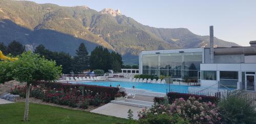 a building with a swimming pool in front of mountains at Un moment de détente inoubliable Saillon-les-Bain in Saillon
