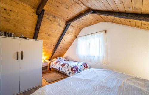 a attic bedroom with a bed and a window at Gorgeous Home In Plesivica With Kitchen in Plešivica