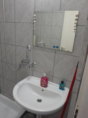 a bathroom with a white sink and a mirror at Relax apartman in Nagykanizsa