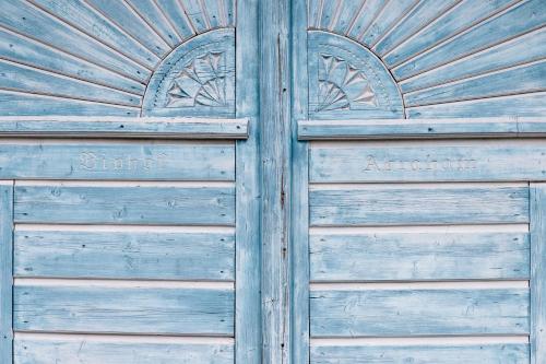 a pair of wooden doors with the words amsterdam on them at Biohof Abraham - Hofkäserei in Gossenreith
