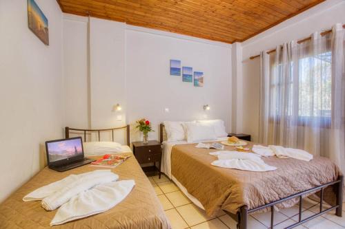 a bedroom with two beds and a laptop on the floor at Christinas apartments in Ágios Matthaíos