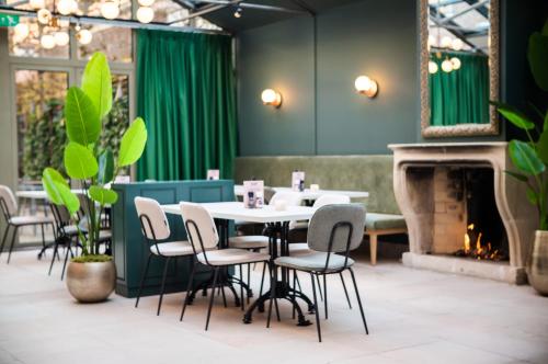 uma sala de jantar com uma mesa e cadeiras e uma lareira em Hotel Halbert em Groningen