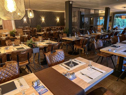 Auberge Les Tilleuls في سان جوريوز: مطعم بطاولات وكراسي خشبية في الغرفة