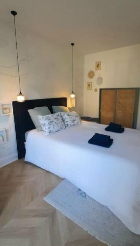 - un grand lit blanc dans une chambre avec deux lumières dans l'établissement Chez Sophie, à Paris