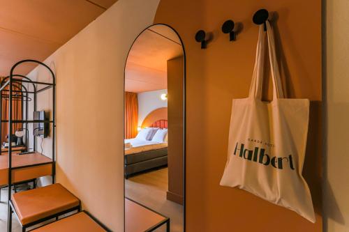 ein Spiegel hängt an einer Wand neben einem Schlafzimmer in der Unterkunft Hotel Halbert in Groningen