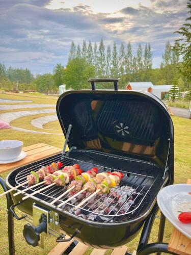 a grill with hot dogs and other food on it at SOL Glamping at Khao yai in Ban Nong Makha
