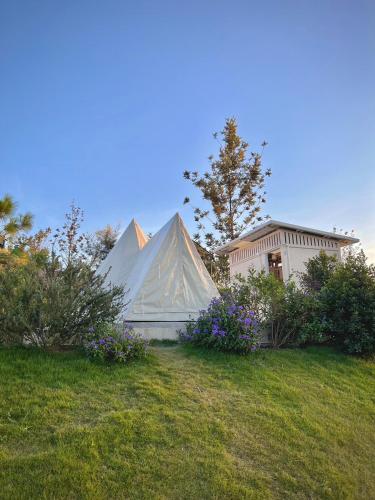 a marquee in a yard with flowers and a house at SOL Glamping at Khao yai in Ban Nong Makha