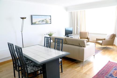 un soggiorno con un tavolo e un divano di Noble dune a Oostduinkerke