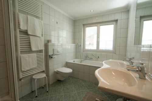 a bathroom with a sink and a tub and a toilet at Ferienhaus & Apart Post in See