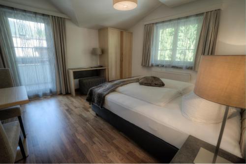 um quarto com uma cama, 2 janelas e um candeeiro em Ferienhaus & Apart Post em See