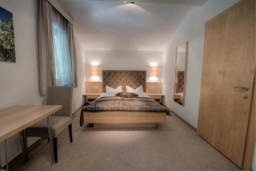 a bedroom with a bed and a table and a desk at Ferienhaus & Apart Post in See