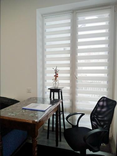 a room with a table and chairs and a large window at Family Apartments Dorobok in Lviv