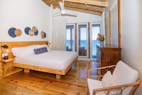 una camera con letto e un balcone con vista sull'oceano di Wow! Views and more, fantastic 2 bedroom in West End - Villa Agua apts a Roatán