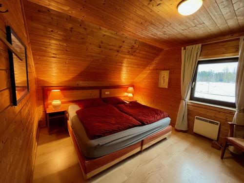 a bedroom with a bed in a wooden cabin at JS Feriendomizile Haus Abendrot in Hasselfelde