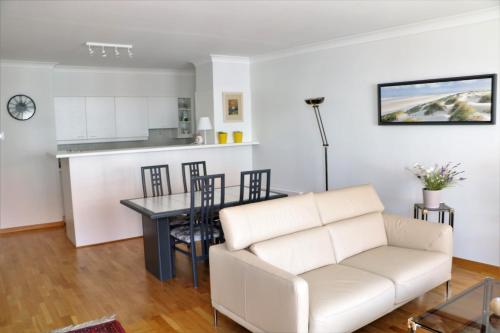 un soggiorno con un divano bianco e un tavolo di Noble dune a Oostduinkerke