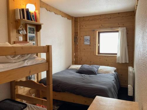 1 dormitorio con litera y ventana en Appartement Alpe Huez 8 personnes centre station en LʼHuez