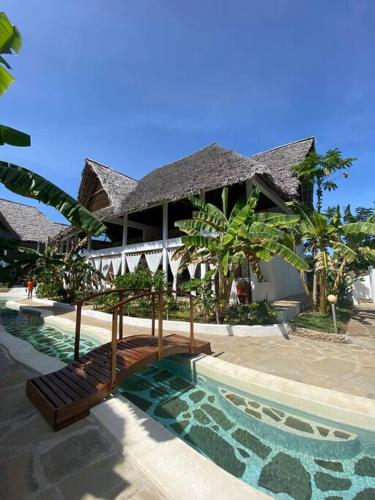 un edificio resort con piscina frente a él en Tembo House - Rafiki Village en Watamu