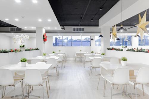a dining room with white tables and white chairs at Palazzo Lakeside Hotel in Kissimmee