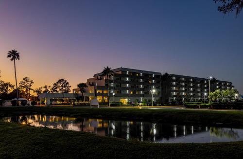 a large building with a reflection in a body of water at Palazzo Lakeside Hotel in Kissimmee