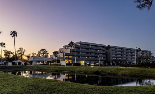 a building with a pond in front of it at Palazzo Lakeside Hotel in Kissimmee