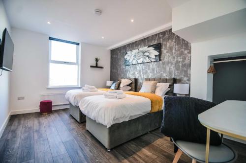 York Crescent Apartments في يورك: غرفة نوم بسريرين وطاولة فيها