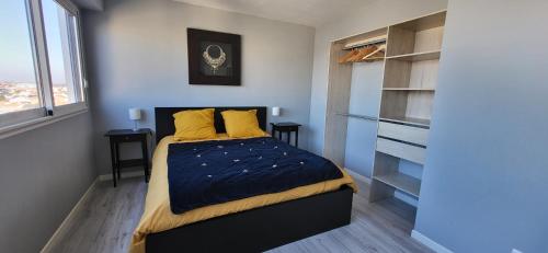 1 dormitorio con 1 cama con almohadas amarillas en Mon Soleil en Les Sables-dʼOlonne