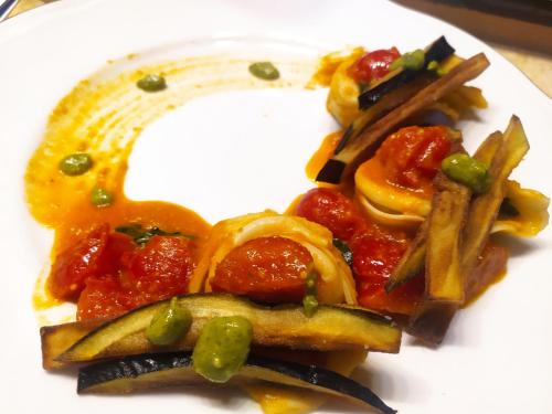 un plato blanco de comida con pasta y verduras en Isola Blu, en Taranto