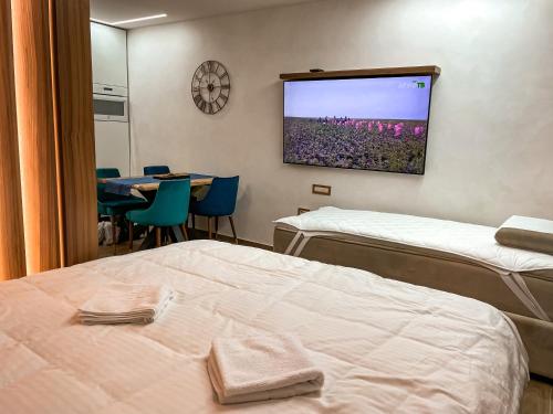 a room with two beds and a tv on the wall at Diamond Kopaonik Centar 2 in Kopaonik