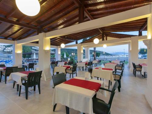 um restaurante com mesas e cadeiras com vista para o oceano em Bitez Kassandra Hotel em Bitez