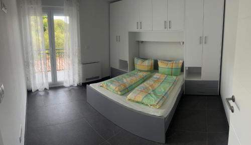 ein Schlafzimmer mit einem großen Bett mit Kissen in der Unterkunft Apartmani Lana in Rab
