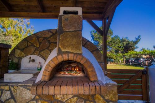 an outdoor oven with a pizza in it at Christinas lofts in Ágios Matthaíos