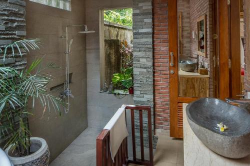 um banheiro com pia e banheira em Alas Petulu Villa Resort and Spa em Ubud