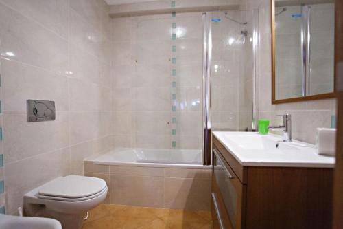 y baño con bañera, aseo y lavamanos. en Quinta da Gomeira, en Cabanas de Tavira